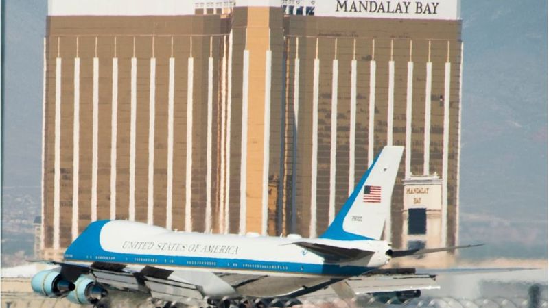 El avión presidencial de EE.UU. aterriza en Las Vegas. En el fondo, el hotel desde el que se perpetró la masacre. En la foto se aprecia la ventana rota del piso 32, desde la que el tirador disparó a la multitud. (AFP).