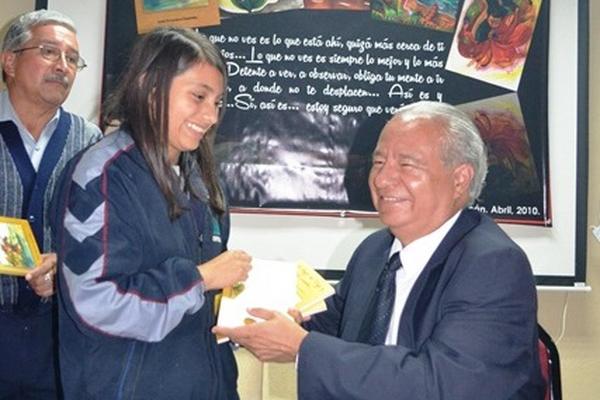 Escritor Juan Francisco Guzmán, de Sololá entrega libro a una estudiante. (Foto Prensa Libre: Édgar René Sáenz)