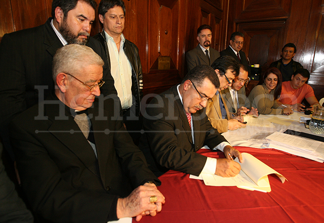 El rector de la Universidad de San Carlos, Estuardo Gálvez firma el acuerdo con la asociación EPA, observa el cardenal Rodolfo Quezada el 29 de septiembre de 2010. (Foto: Hemeroteca PL)