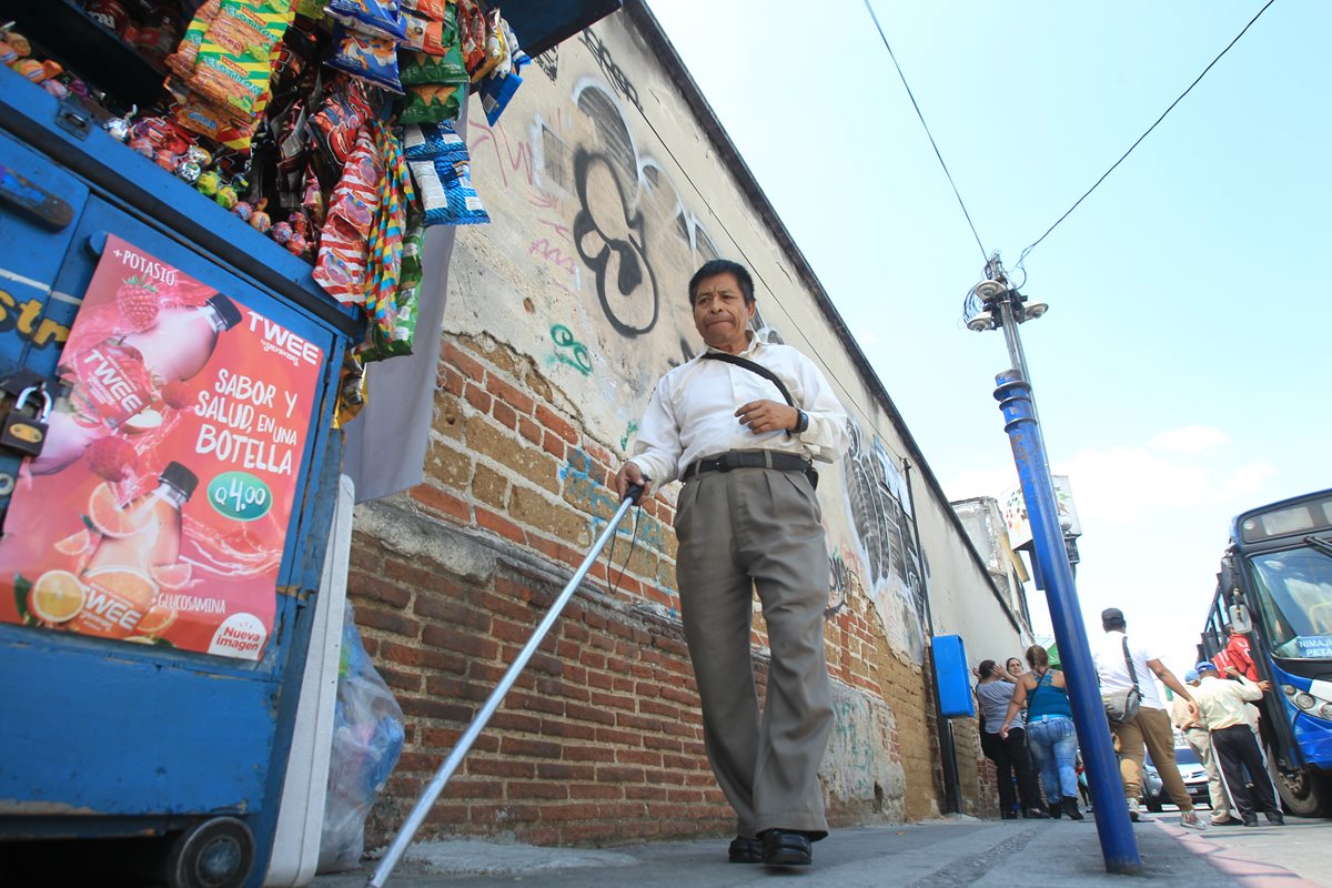 Julián Velásquez, persona no vidente , encuentra obstáculos durante su camina por la 4a. avenida, zona 1. (Foto Prensa Libre: Esbin García)