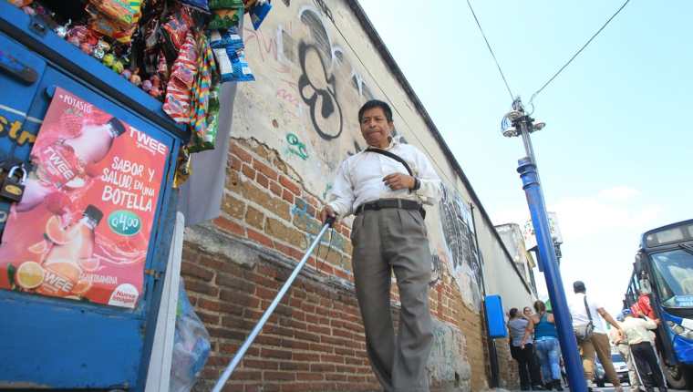 Julián Velásquez, persona no vidente , encuentra obstáculos durante su camina por la 4a. avenida, zona 1. (Foto Prensa Libre: Esbin García)