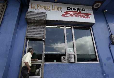 Un hombre espera en una ventanilla del Diario Extra de Costa Rica para ser antendido. (Foto Prensa Libre: EFE).
