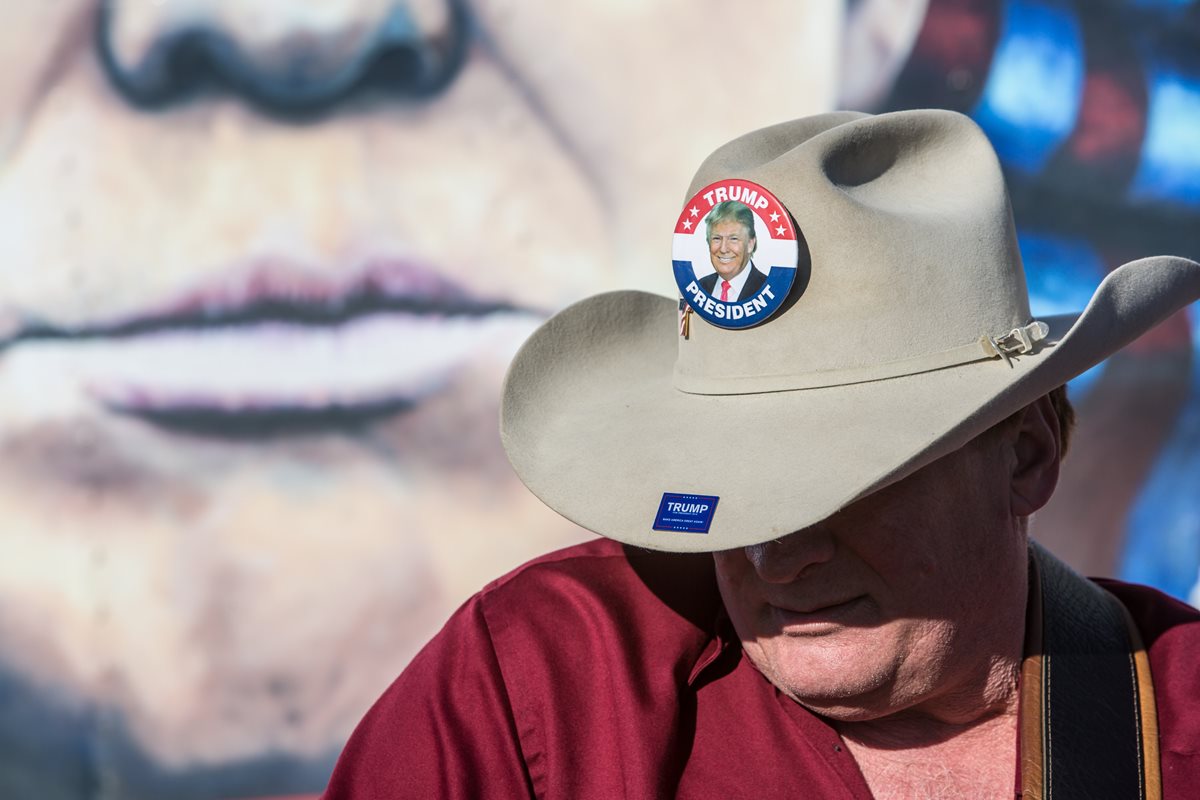 Un seguidor de Donald Trump posa con un sombrero en el que luce la imagen del precandidato republicano. (Foto Prensa Libre: AFP).