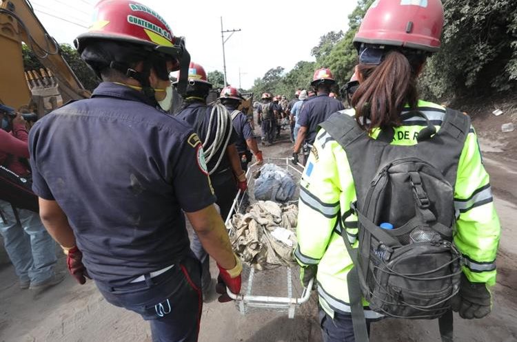 Bomberos han sido protagonistas en tragedias. En la foto, el rescate de víctimas de la erupción del Volcán de Fuego. (Foto Prensa Libre: Hemeroteca PL)