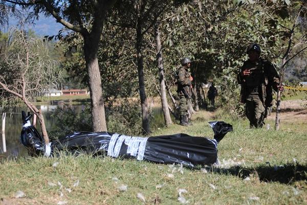 Personal del Ejército resguarda el lugar en donde fue localizado el cadáver de una mujer. (Foto Prensa Libre: Mike Castillo). 