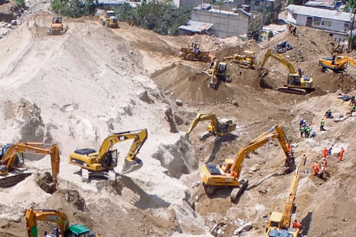 Las pertenencias de las víctimas que murieron por el alud que soterró sus viviendas son recuperadas de entre los escombros por socorristas.