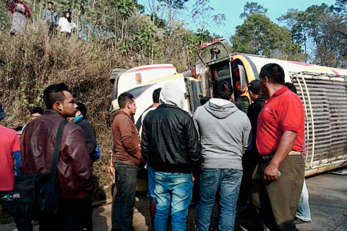 Vecinos de  San Martín Jilotepeque, Chimaltenango observan autobús accidentado en el km 76 de la ruta Interamericana. (Foto Prensa Libre: Ángel Elías)