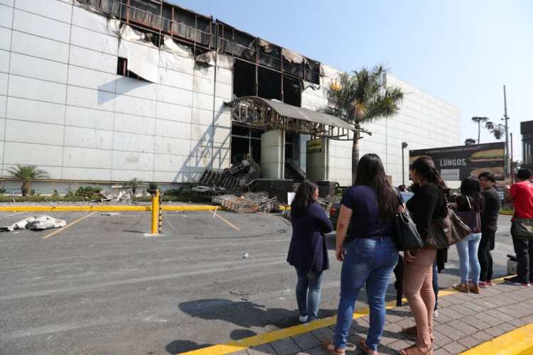 Varios trabajadores del centro comercial y algunos curiosos miraban cómo quedó la fachada del lugar, luego del incendio. 