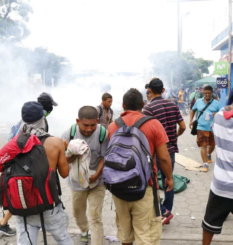 Migrantes hondureños fueron afectados por lo gases lacrimógenos que lanzaron agentes de la Policía Nacional Civi. (Foto Prensa Libre: Rolando Miranda)