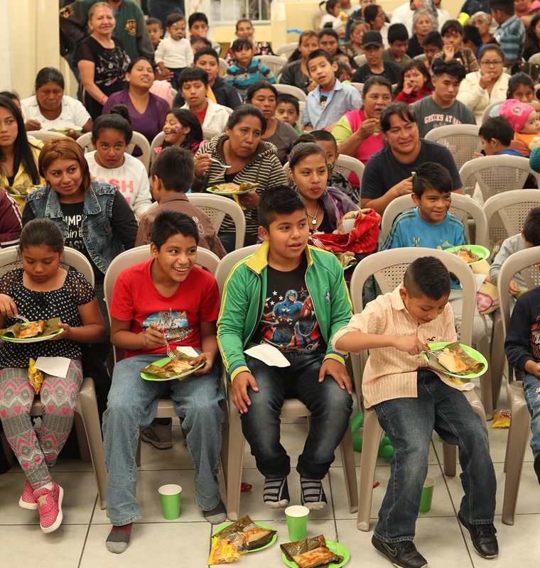 Los niños comen tamales durante el convivio navideños que les organizó la asociación Libre Infancia y Maseca en la zona 3. (Foto Prensa Libre)