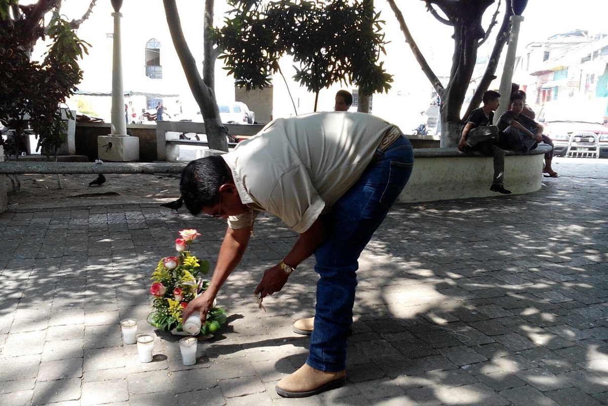 Vecino enciende veladoras en el parque central de Mazatenango, donde hace un año ocurrió el ataque contra dos periodistas. (Foto Prensa Libre)