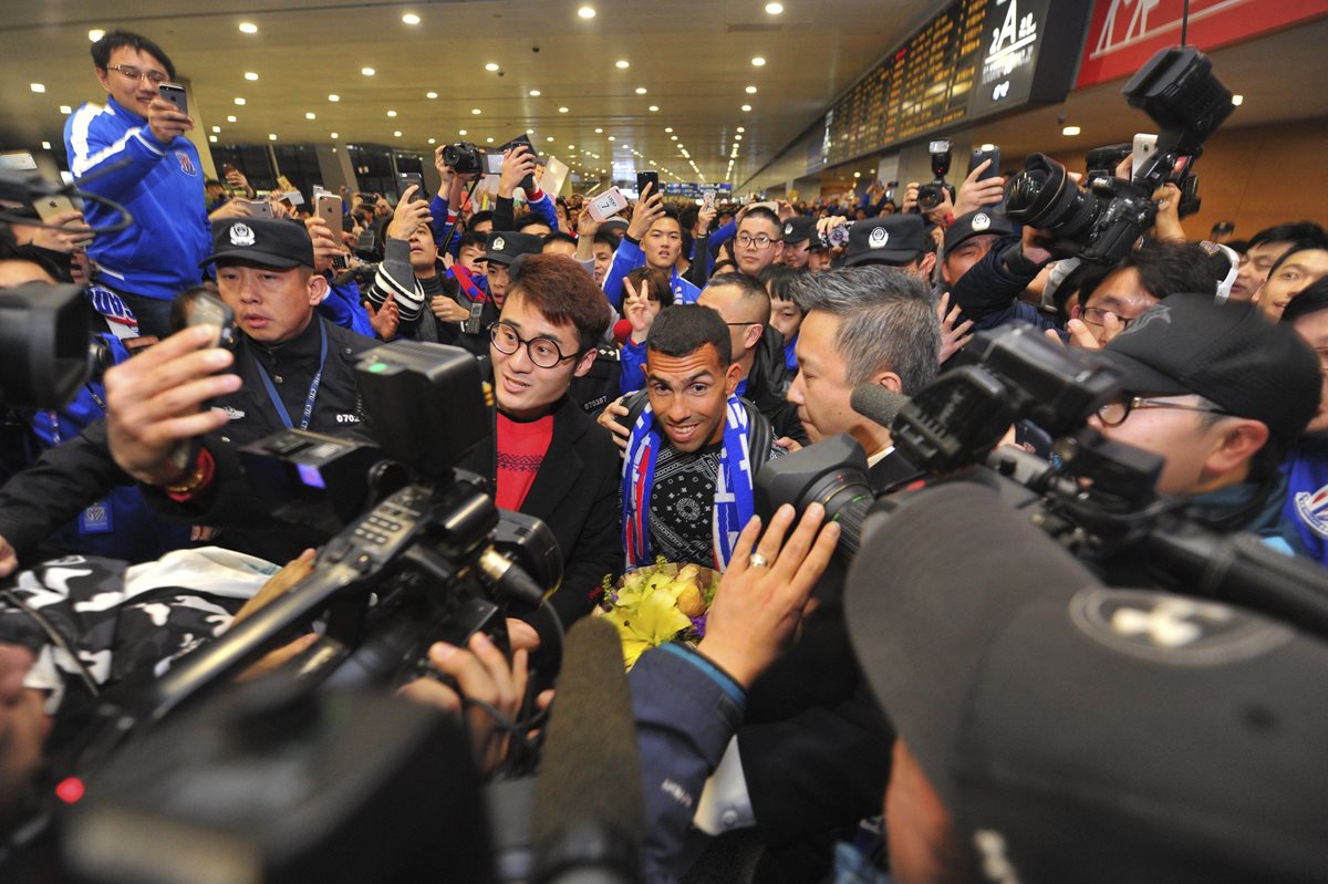 Carlos Tevez fue recibido por una multitud en el aeropuerto de Shanghai. (Foto Prensa Libre: EFE).