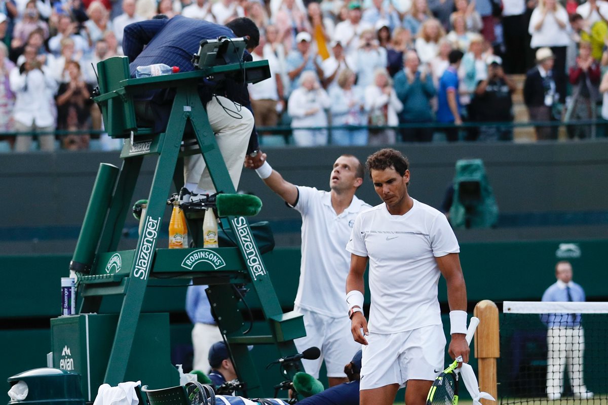 Rafael Nadal sale de la cancha cabizbajo luego de quedar eliminado por Gilles Muller en el torneo de Wimbledon. (Foto Prensa Libre: AFP)