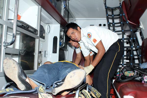 Un Bombero Voluntario asiste a uno de los tres heridos en el Asintal Retalhuleu. (Foto Prensa Libre: Rolando Miranda)