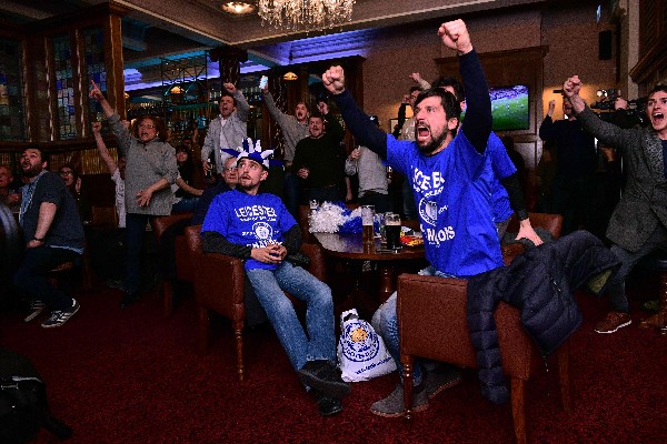 Los aficionados del Leicester celebran la corona, tras el empate del Chelsea y el Tottenham. (Foto Prensa Libre: AP)