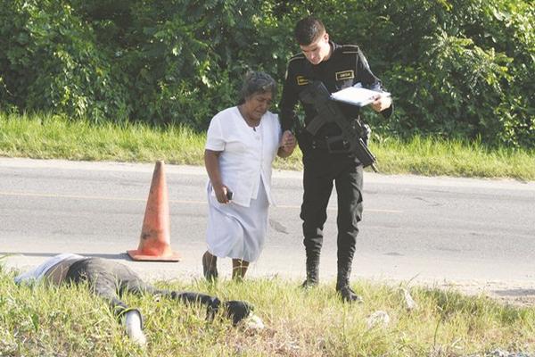 Un agente de la PNC acompaña a María Linares, madre del hombre que fue atropellado. (Foto Prensa Libre: Edwin Perdomo)