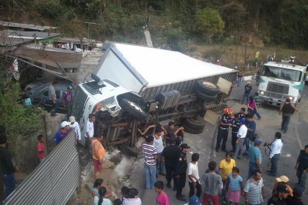 Bomberos, policías y curiosos en el lugar donde volcó el camión comercial. (Foto Prensa Libre: Miguel López)<br _mce_bogus="1"/>