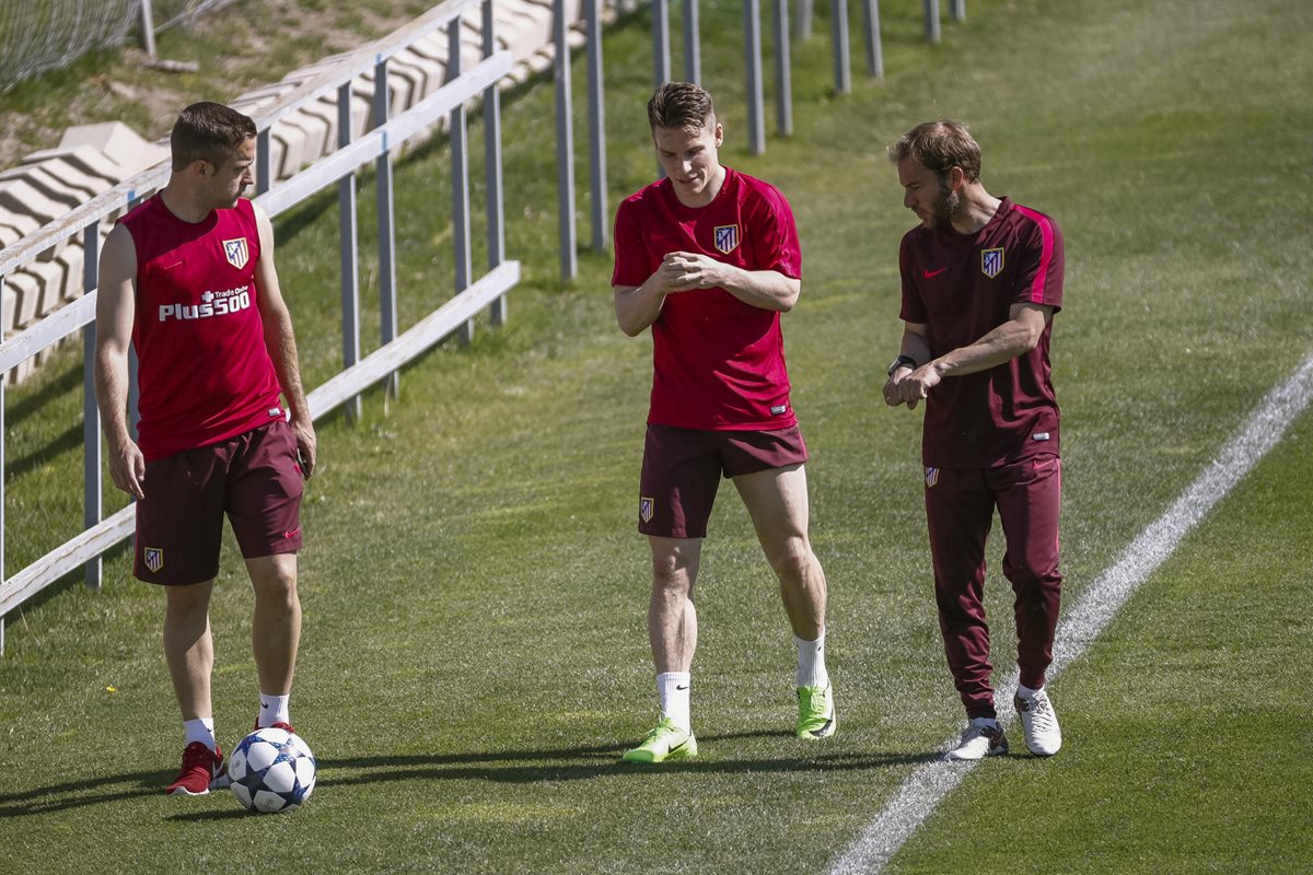 El delantero francés del Atlético de Madrid Kevin Gameiro (c) conversa con dos miembros del cuerpo técnico durante el entrenamiento realizado hoy. (Foto Prensa Libre: EFE)