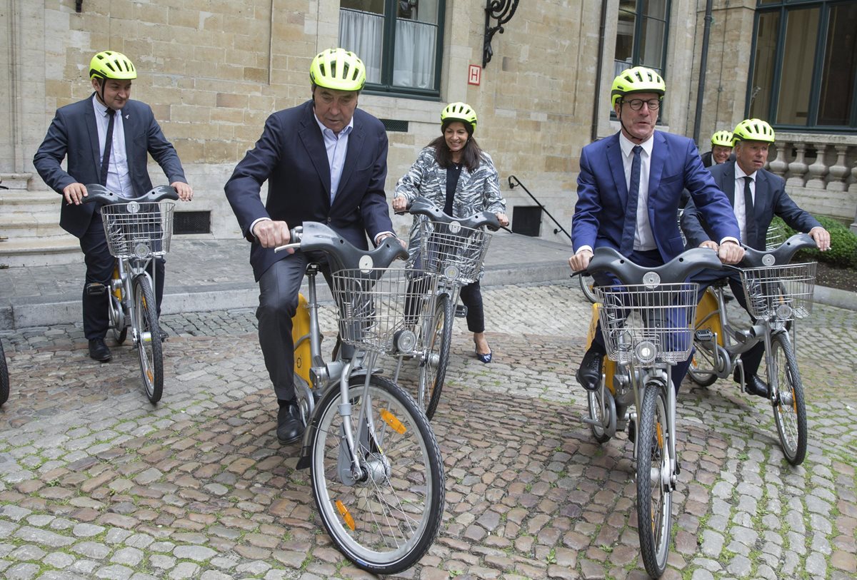 La leyenda belga del ciclismo, Eddy Merckx, la alcaldesa de París, Anne Hidalgo y el alcalde de Bruselas, Yvan Mayeur, montan en bicicleta tras asistir a una rueda de prensa para presentar el Tour de Francia de 2019 en Bruselas. (Foto Prensa Libre: EFE)