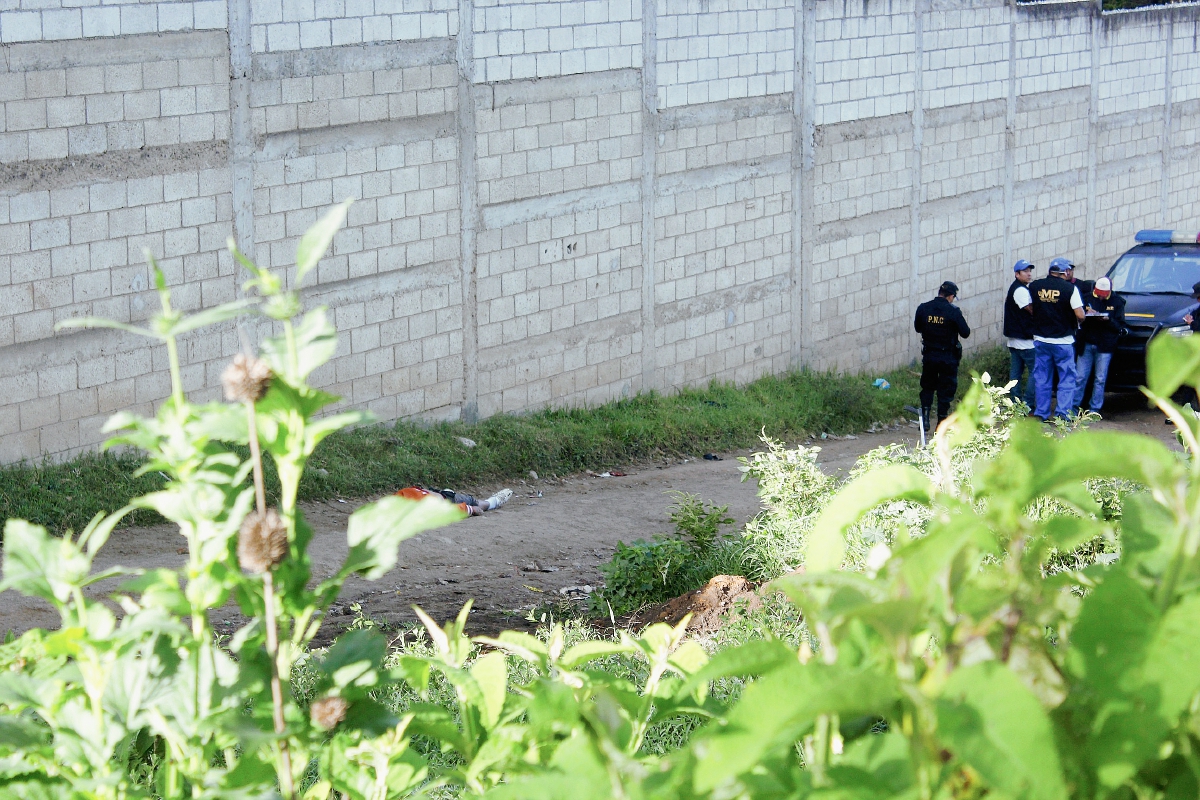 Peritos del Ministerio Público y autoridades policiales dialogan acerca de la muerte de hombre, en la cabecera de Chimaltenango. (Foto Prens Libre: Víctor Gómez)
