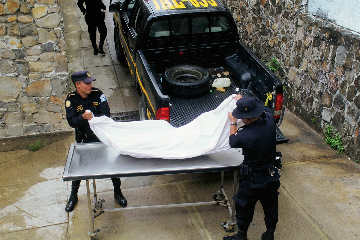 El cadáver de un hombre que fue decapitado es llevado a la morgue de Jalapa por agentes de la PNC. (Foto Prensa Libre: Hugo Oliva)