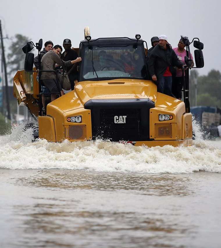 Varias personas son evacuadas de sus hogares después de que el área fuera inundada. (AFP).