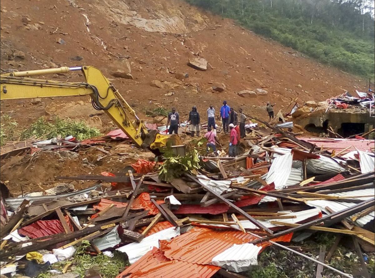 Varias personas observan los daños causados por corrimiento de tierra al este de Freetown, Sierra Leona. (AP).