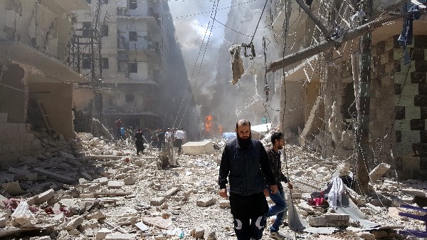 Sirios en el lugar de los ataques aéreos en el barrio Bustan Al Qasr en Alepo. (Foto Prensa Libre: EFE)