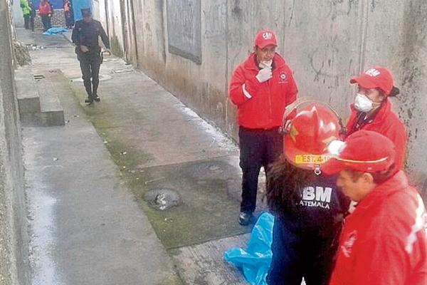 Socorristas, junto a restos de una mujer desmembrada que aparecieron en bolsas, en Mixco. (Foto Prensa Libre: CBM)