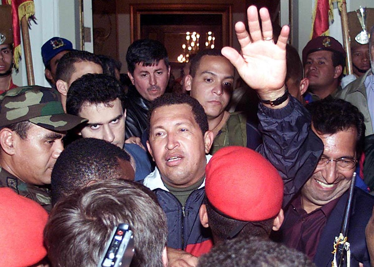 Hugo Chávez saluda a sus camaradas a su llegada al Palacio de Miraflores para reasumir al poder. (Foto: AFP)