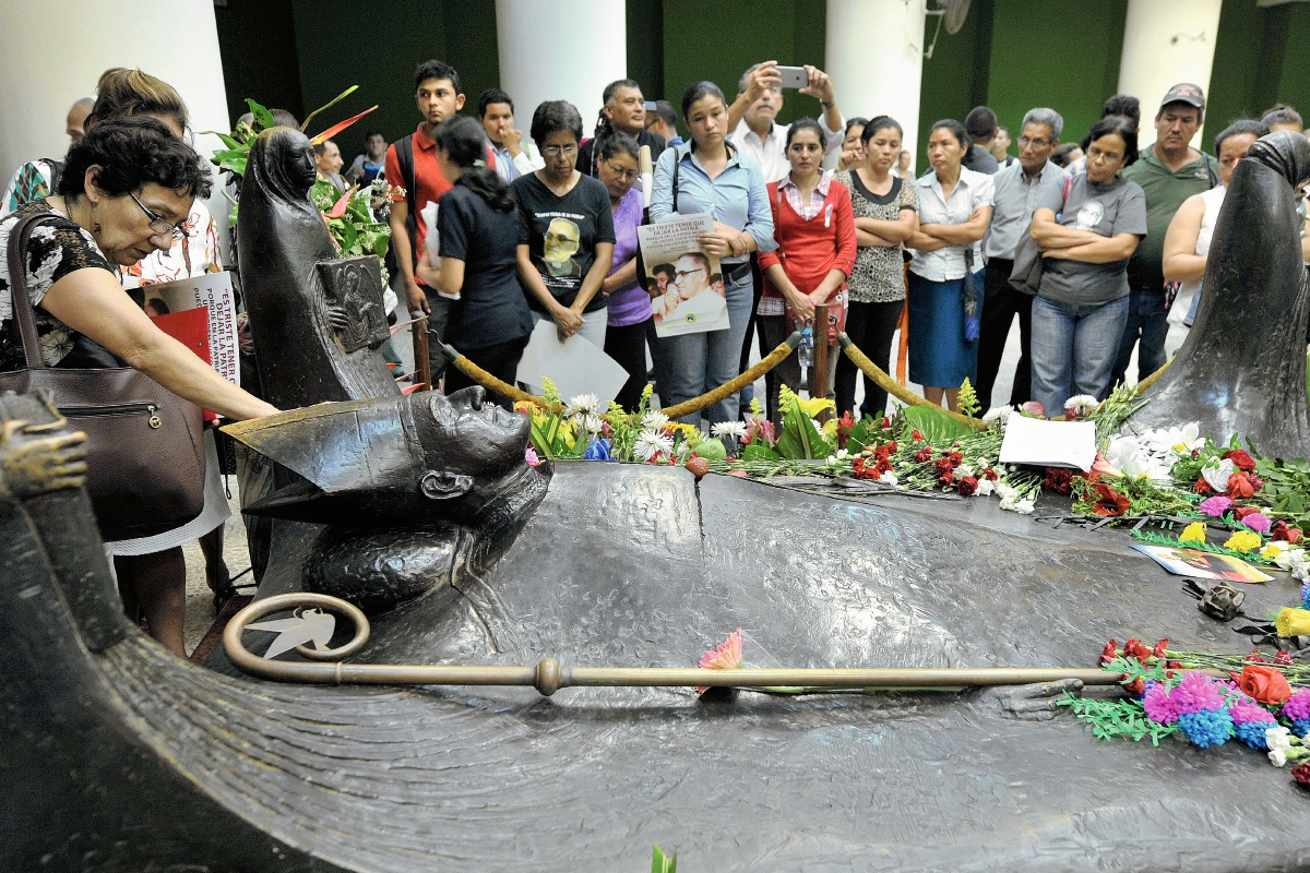 Devotoa del monseñor Óscar Arnulfo Romero rodean su tumba en la catedral de San Salvador. (Foto Prensa Libre: AFP)
