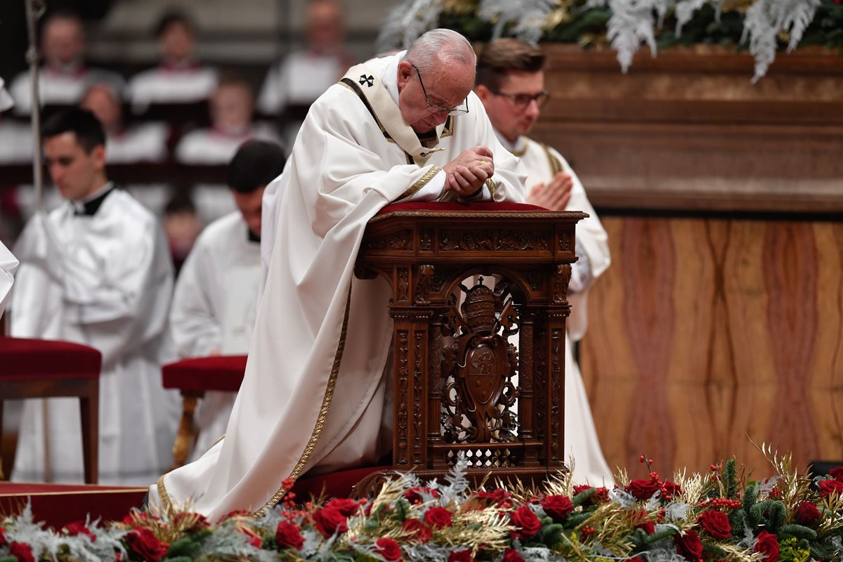 El Papa reza mientras celebra la misa la víspera de Navidad que marca el nacimiento de Jesucristo.(AFP).
