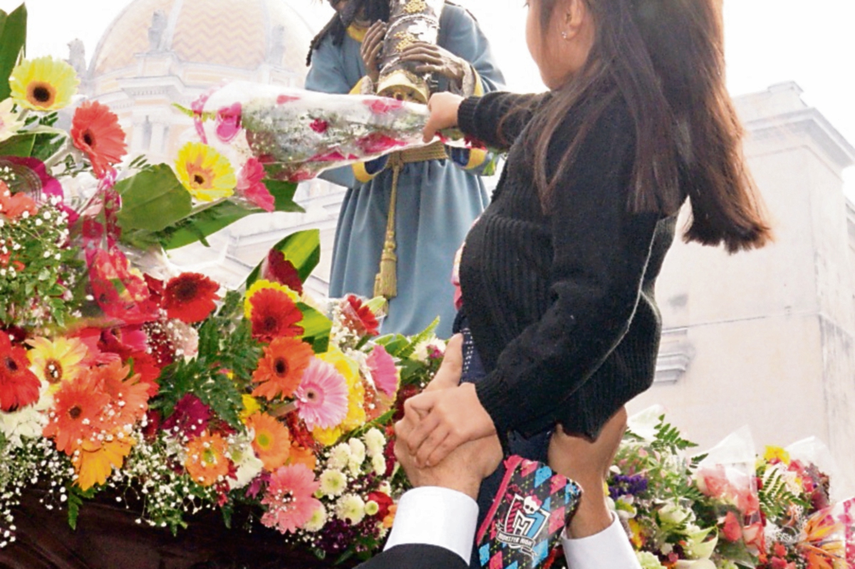 El Patrón Jurado recibe ramos de flores de los niños que asisten a la procesión de La Reseña.