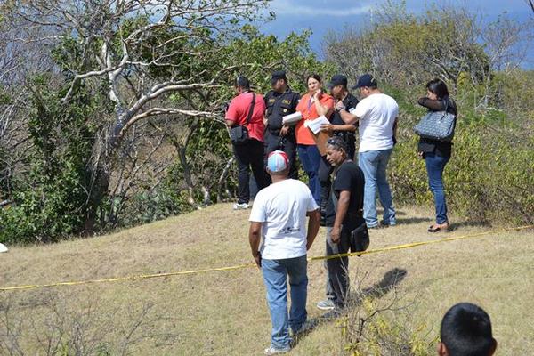 Autoridades inspeccionan el cadáver del joven. (Foto Prensa Libre: Víctor Gómez).