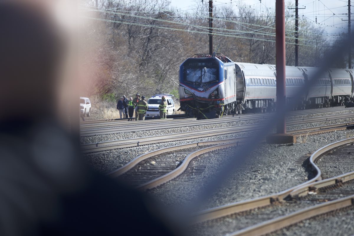 Un hombre observa a los equipos de emergencia trabajar en el lugar del accidente. (Foto Prensa Libre: AFP).