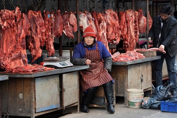 Una vendedora de carne de cerdo en China espera clientela, mientras que el gobierno se muestra preocupado por el encarecimiento de la vida. (Foto Prensa Libre: AFP)<br _mce_bogus="1"/>