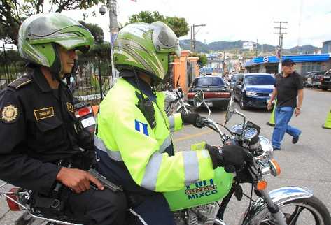 Un agente  de la Policía Nacional Civil patrulla las calles de Mixco con apoyo de un agente de Tránsito.