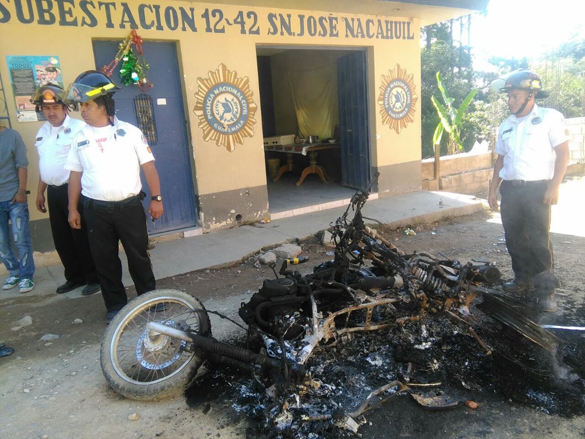 Bomberos observan las motocicletas destruidas por la turba. (Foto Prensa Libre: Estuardo Paredes)
