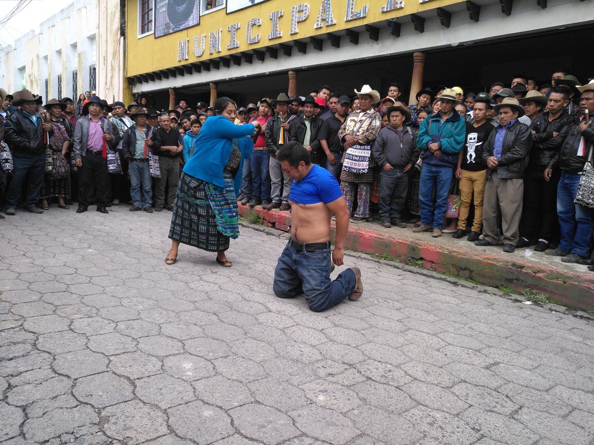 Uno de los sentenciados recibe 20 azotes por su padre, frente a la Municipalidad de Sololá. (Foto Prensa Libre: Ángel Julajuj)