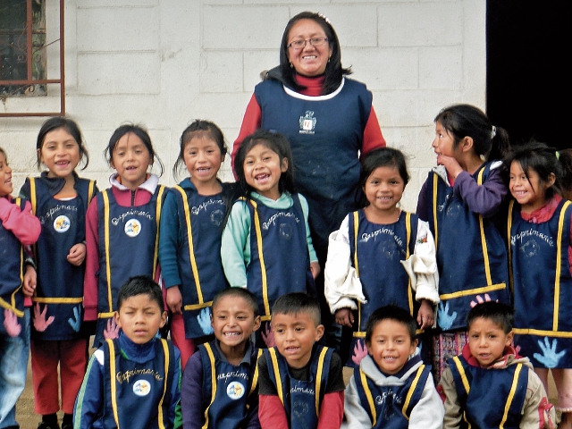 Sonia Menchú, junto a una de sus promociones de preprimaria, en la escuela rural de Totonicapán donde trabaja desde hace 11 años. (Foto Prensa Libre: María José Longo)