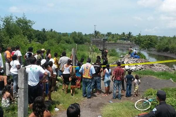 Curiosos observan los dos cadáveres encontrados en Puerto San José, Escuintla. (Foto Prensa Libre) <br _mce_bogus="1"/>