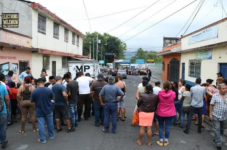 Curiosos se aglomeran cerca del lugar donde murió baleada la abogada Ana Beatriz Figueroa, en la zona 1 de Escuintla. (Foto Prensa Libre: Hemeroteca PL)