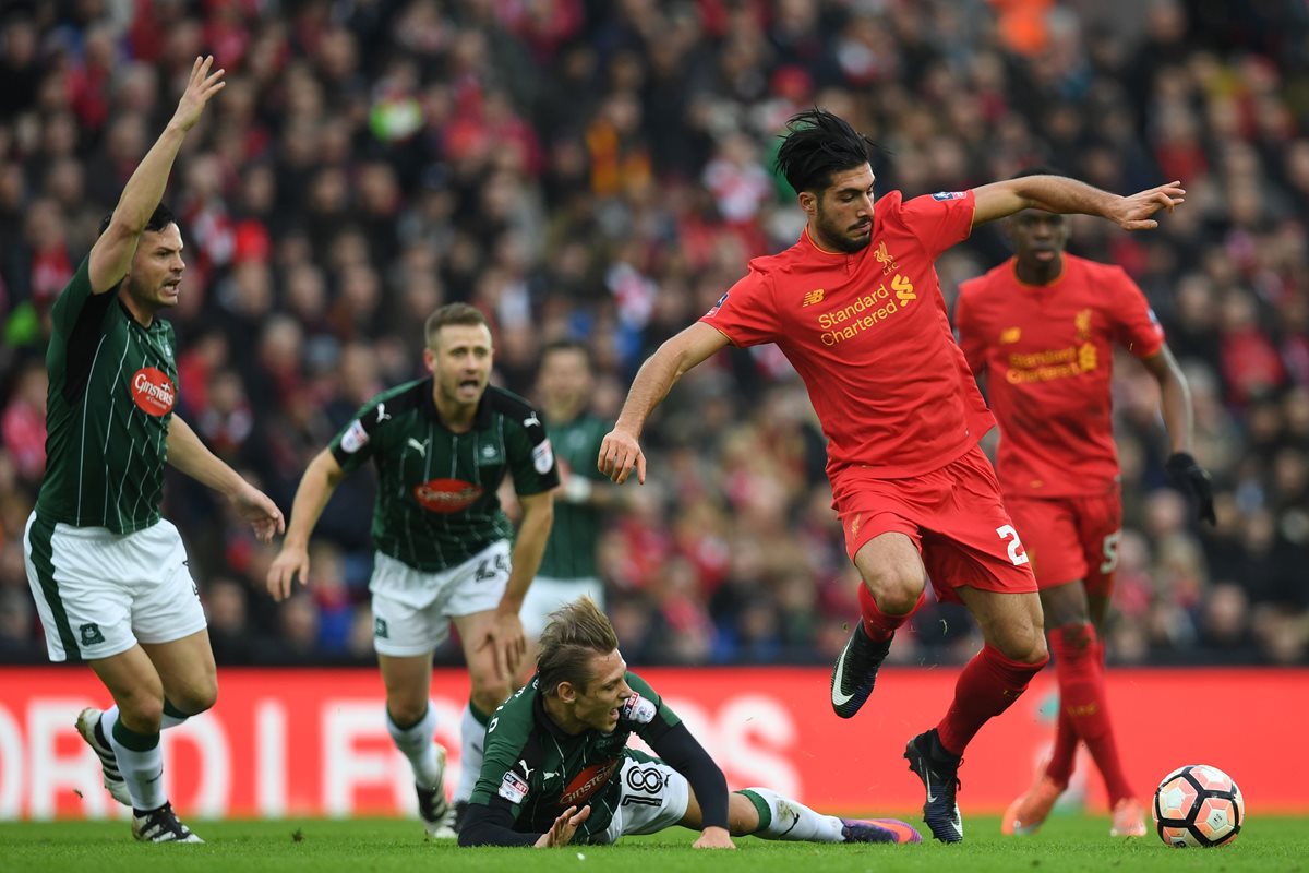 Emre Can trata de llevarse el balón ante la mirada de varios jugadores del Plymouth. (Foto Prensa Libre: AFP)
