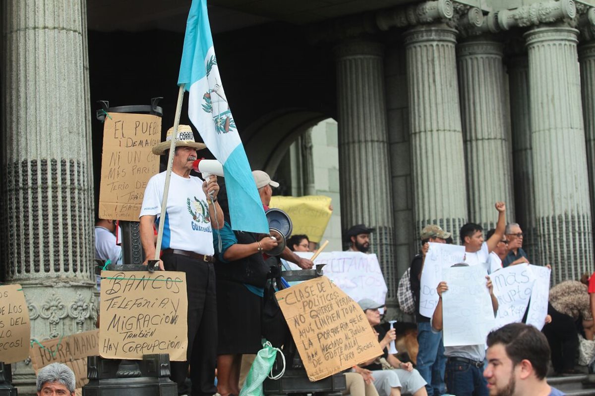 Ciudadanos ondean banderas y exigen que el Ejecutivo dé marcha atrás a la reforma fiscal. (Foto Prensa Libre: Álvaro Interiano)