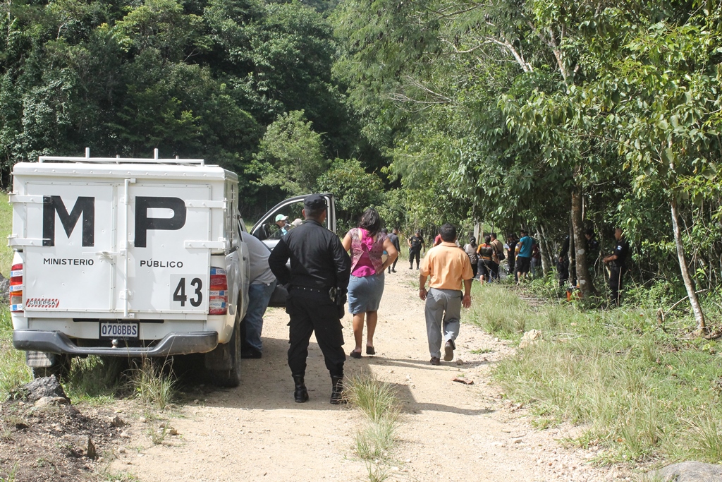 Fiscales del Ministerio Público resguardan el lugar donde ocurrió el crimen, en la aldea Machaquilá, Poptún, Petén. (Foto Prensa Libre: Walfredo Obando)