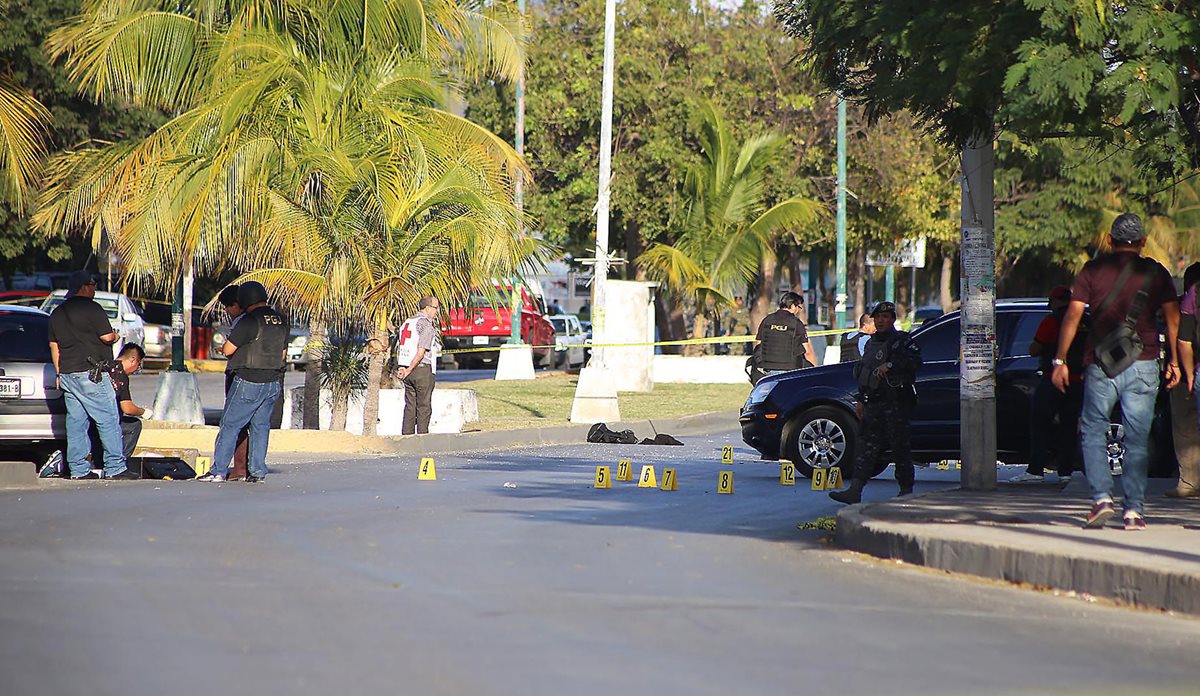 Peritos recaban evidencias en el lugar donde ocurrió la balacera. (Foto Prensa Libre: EFE).