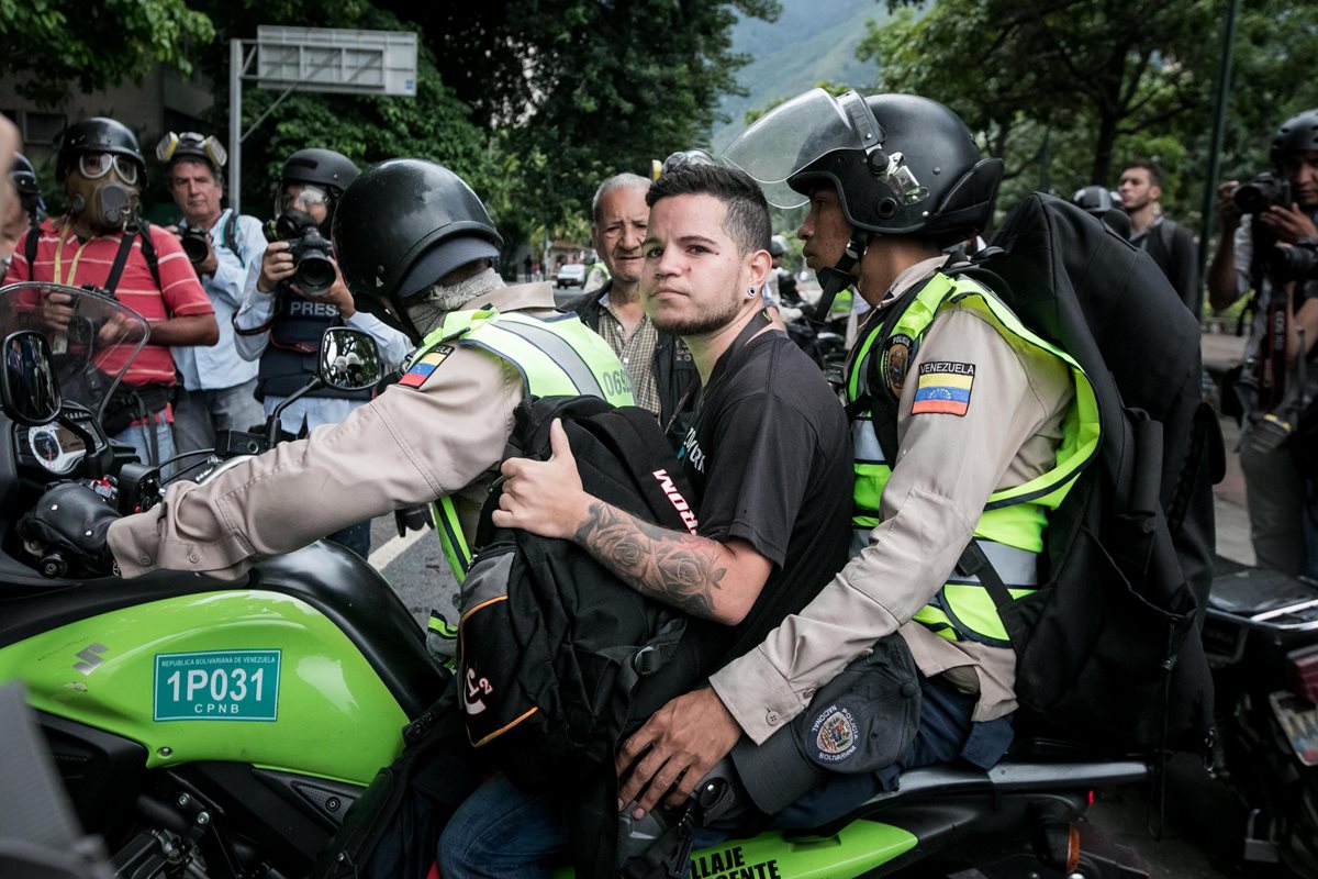 Un opositor es detenido por la Policía Nacional Bolivariana durante una protesta. (EFE).