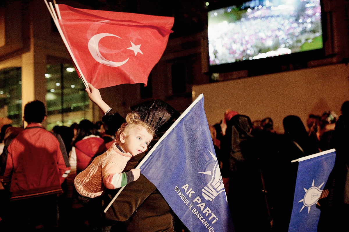 Seguidores del  partido  Justicia y Desarrollo del partido (AKP) ondean banderas del partido y turcos en la sede en Estambul. (Foto Prensa Libre:AFP)