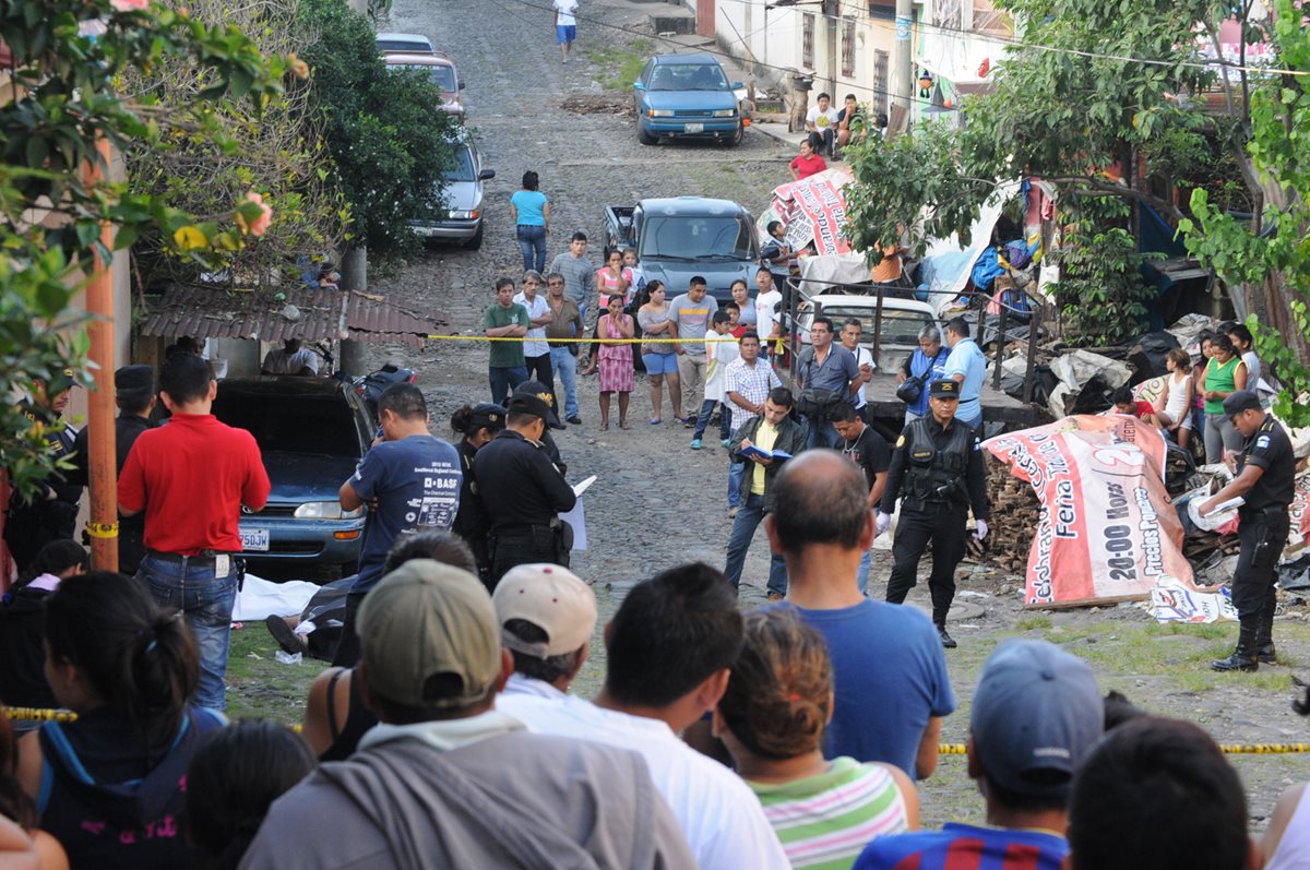 Vecinos observarn los cuerpos de la pareja asesinada este sábado en Coatepeque, Quetzaltenango. (Foto Prensa Libre: Alexander Coyoy)