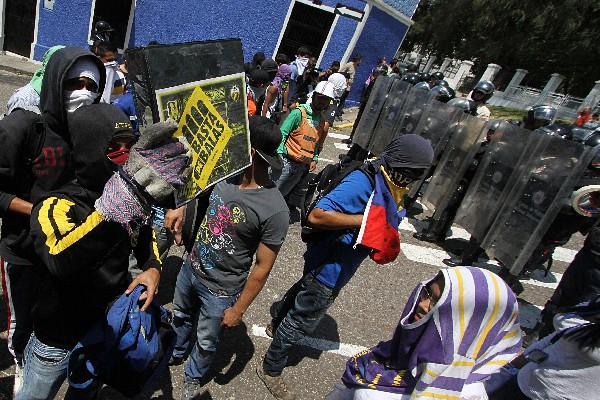 Un grupo de estudiantes, frente a policías antidisturbios durante la protesta, en San Cristóbal, Venezuela. (Foto Prensa Libre: AFP